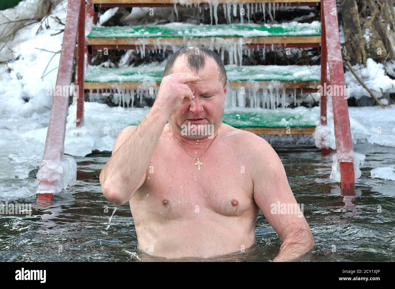 Erwachsener Mann, der sich taufte, bevor er während des Dreikönigsfestes am Dnipro River in eisiges Wasser tauchte. Januar 19, 2017. Kiew, Ukraine Stockfoto