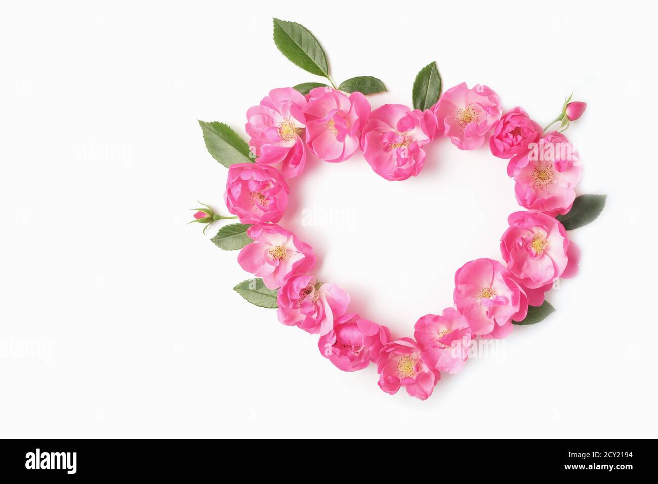 Herz aus Köpfen und Knospen aus Rosen und Blättern auf weißem Hintergrund. Draufsicht und Kopierbereich. Valentinstag-Konzept. Stockfoto