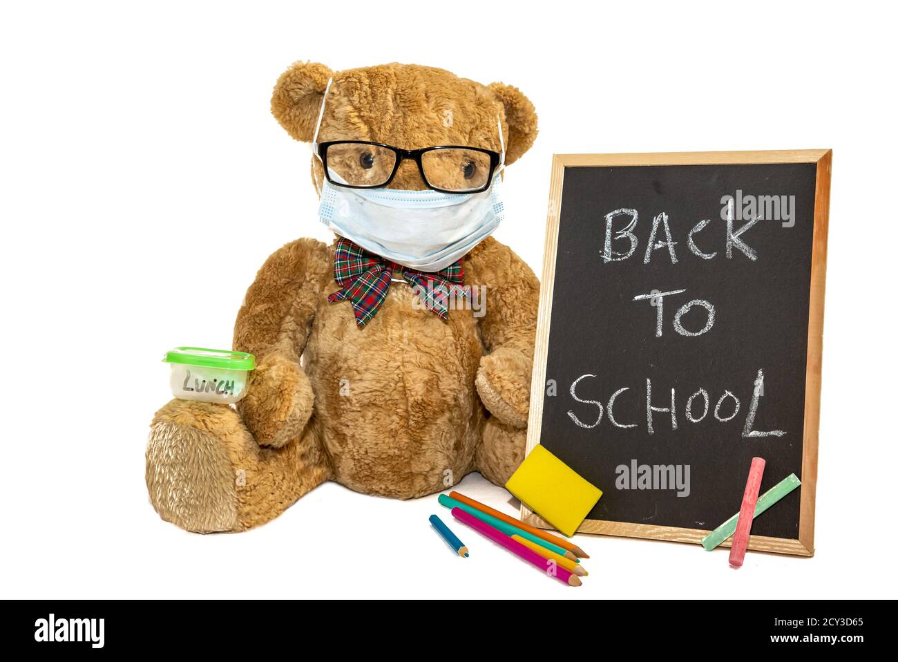 Niedlicher Teddybär geht zurück in die Schule trägt eine Gesichtsmaske als Schutz gegen das Coronavirus, Covid-19 Pandemie. Querformat, Platz zum Kopieren. Stockfoto