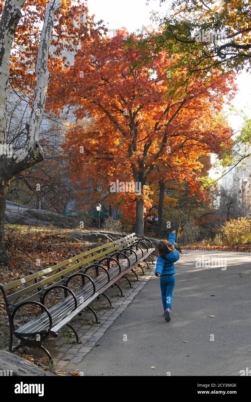 Kind, das im Herbst durch den Zentralpark schlendert Stockfoto