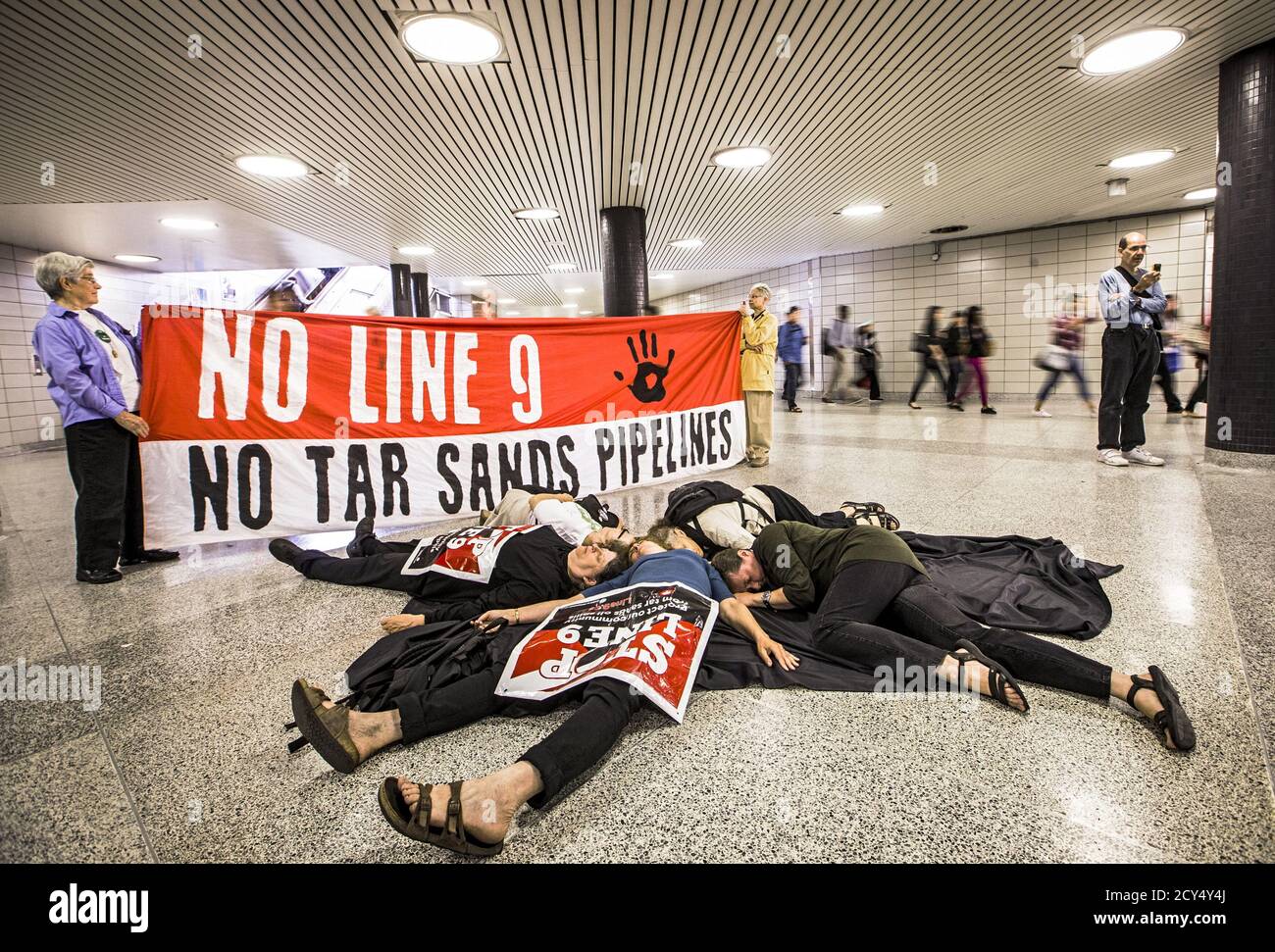 Demonstranten des "Toronto No Line 9 Network" führen einen "Einstand" durch, um zu demonstrieren, was sie sagen, die möglichen Auswirkungen wären, wenn die Enbridge die "Line 9"-Erdölleitung, die unter der Finch-U-Bahn-Station läuft, in Toronto am 29. Juni 2015 zerbrach. Enbridge hat die Erlaubnis gesucht, den Fluss der Pipeline, die vom südlichen Ontario nach Montreal verläuft, umzukehren. Das National Energy Board hat Enbridge beauftragt, hydrostatische Tests durchzuführen, bevor sie mit dem Plan fortfahren können, laut lokalen Medienberichten. REUTERS/Mark Blinch Stockfoto