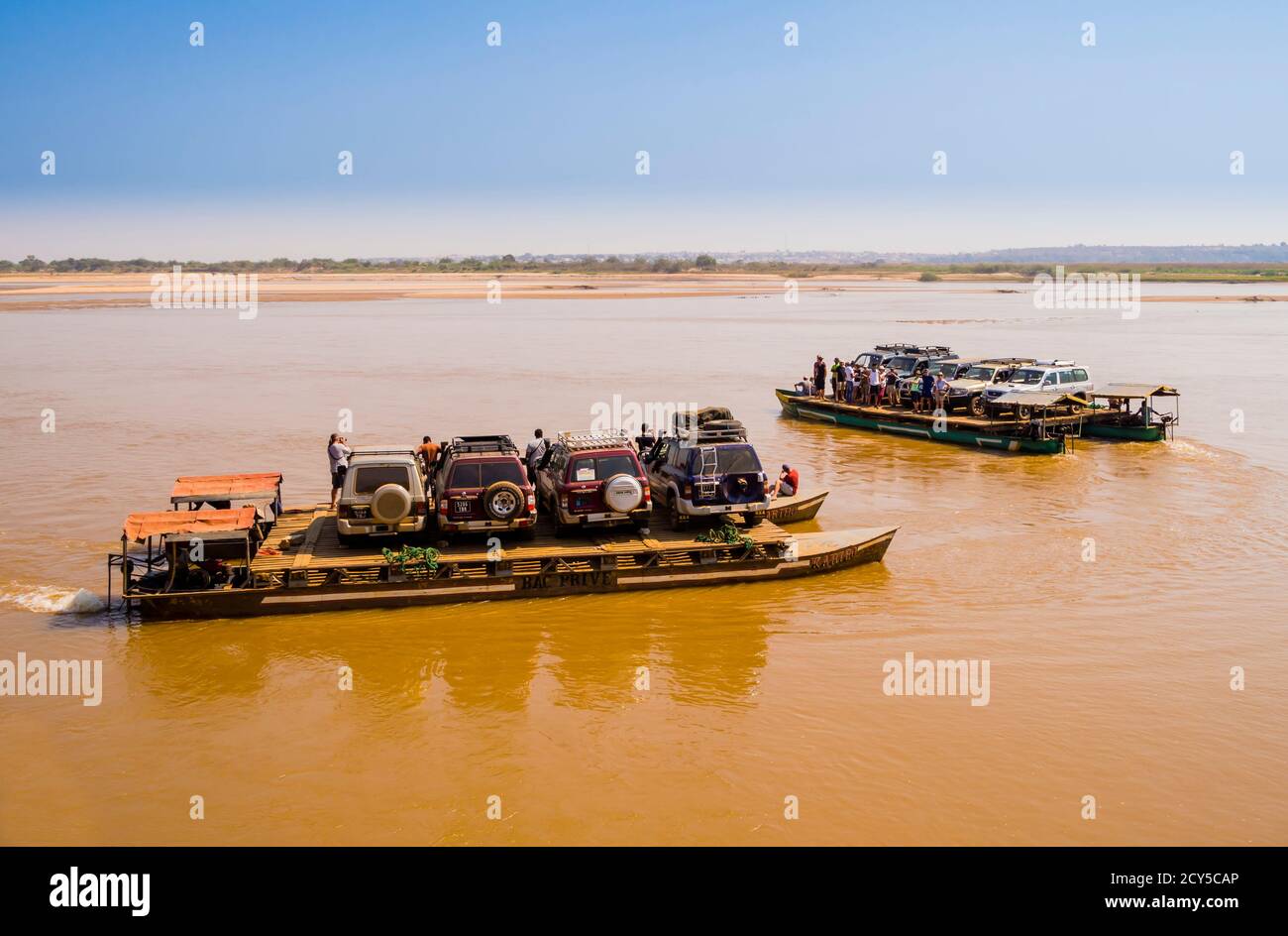 Touristen und Off-Road-Fahrzeuge überqueren Tsiribihina Fluss auf prekären handgefertigten Fähren, Madagaskar Stockfoto
