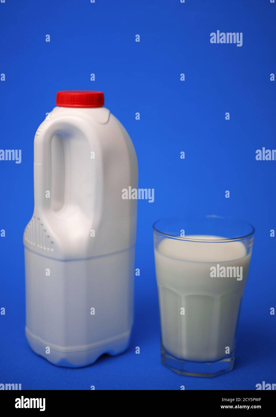 Eine Gallone Milchkännchen mit einem roten Deckel und luftdicht Vollglas Milch auf blauem Hintergrund Stockfoto