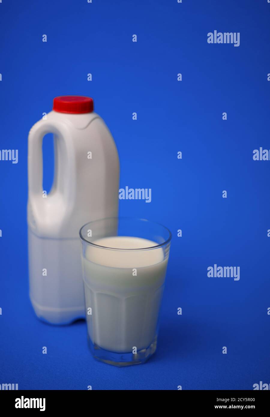 Eine Gallone Milchkännchen mit einem roten Deckel und luftdicht Vollglas Milch auf blauem Hintergrund Stockfoto