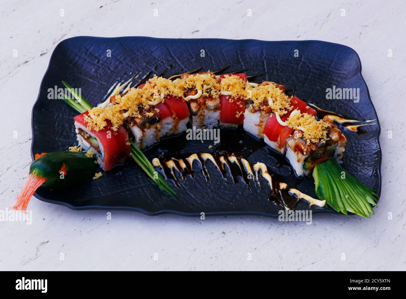 japanisches Drachen Sushi rollt auf einem schwarzen Teller Stockfoto
