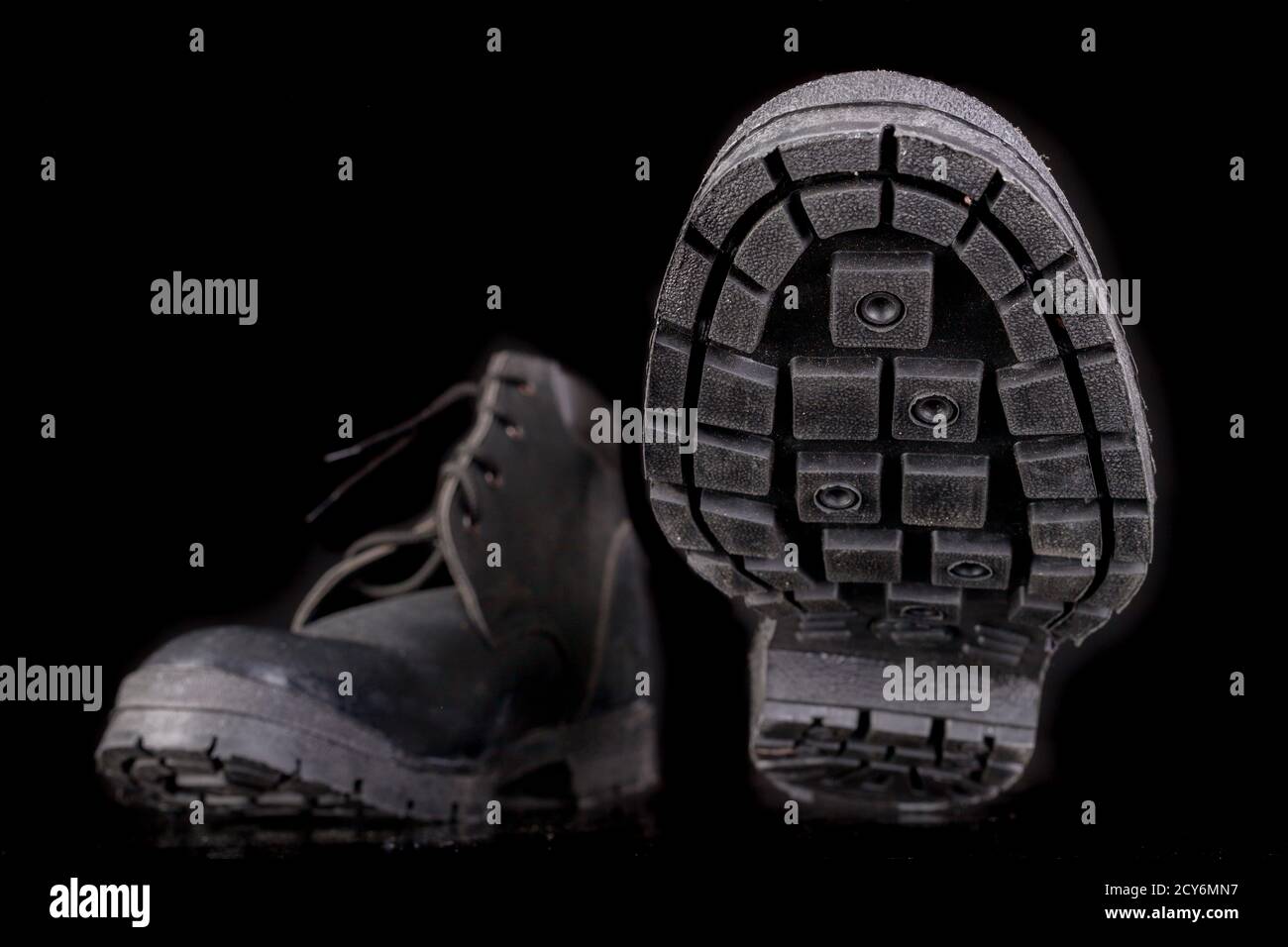 Arbeitsschuhe mit sichtbarer Sohle und Lauffläche. Schuhe für einen Produktionsarbeiter. Dunkler Hintergrund. Stockfoto