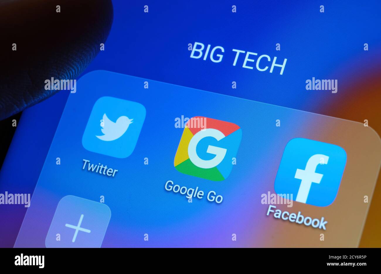 Google, Facebook, Twitter-Apps auf dem Bildschirm gesehen und verschwommener Finger zeigt auf sie. Stockfoto