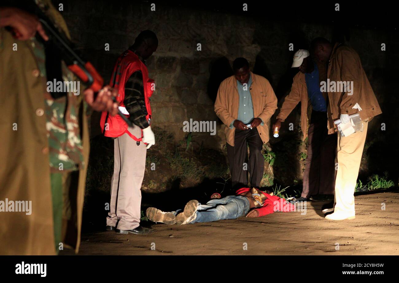 Polizisten kümmern sich um den Körper eines Mannes in einer Explosion in Kenias Hauptstadt Nairobi, 24. Oktober 2011 getötet. Eine Granatenexplosion im Zentrum von Nairobi am Montagabend eine Person getötet und verletzt mindestens acht, der zweite Angriff in der kenianischen Hauptstadt innerhalb von 24 Stunden, sagte die Polizei. REUTERS/Thomas Mukoya (Kenia - Tags: Unruhen Verbrechen Recht TPX Bilder des Tages) Stockfoto