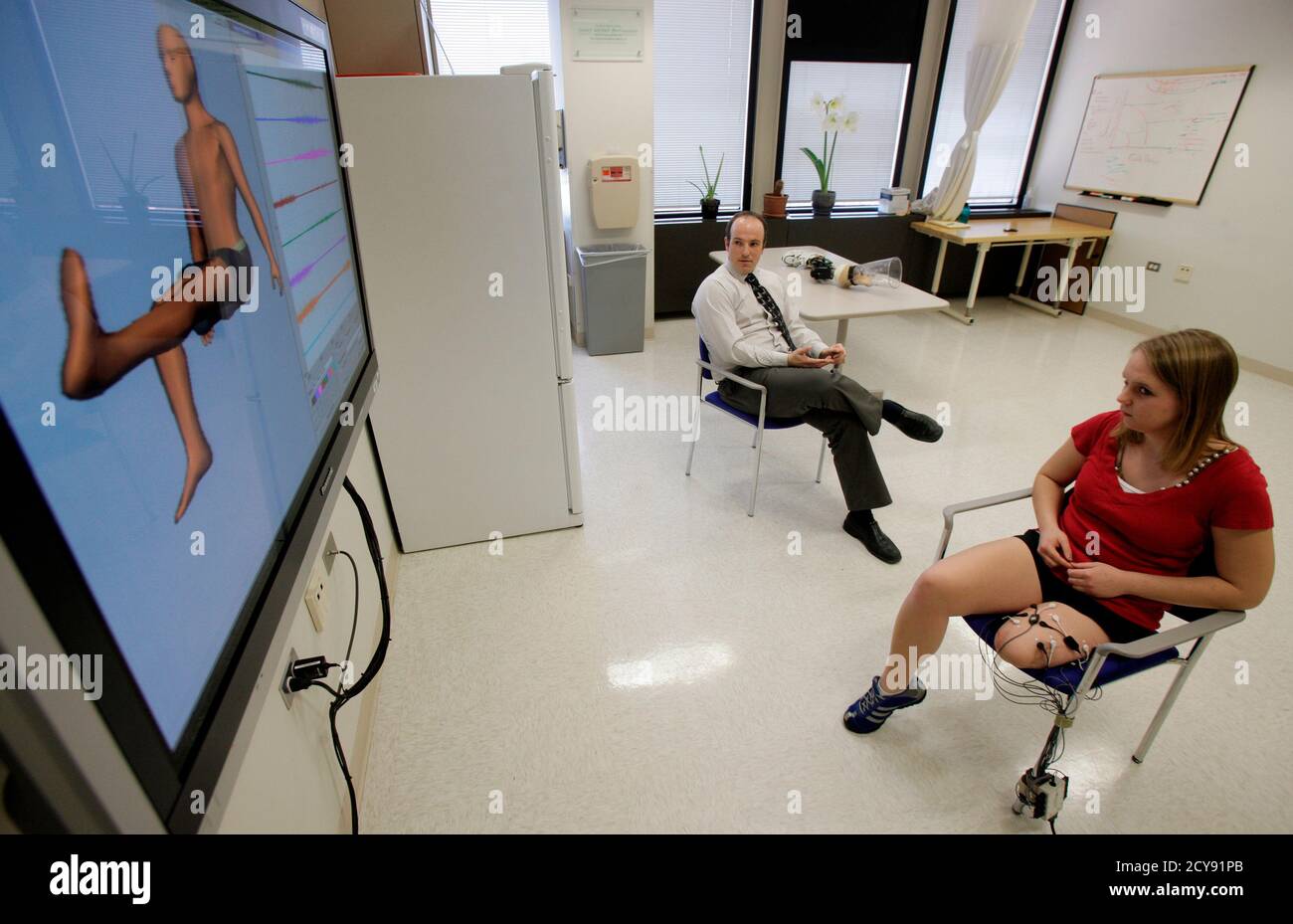 Die Forscherin Levi Hargrove arbeitet mit Hailey Daniswicz (R) zusammen,  als sie am 13. April 2011 in Chicago die Muskeln in ihrem Oberschenkel  beugt, während Elektroden an ihrem Bein einen Computeravatar anweisen,
