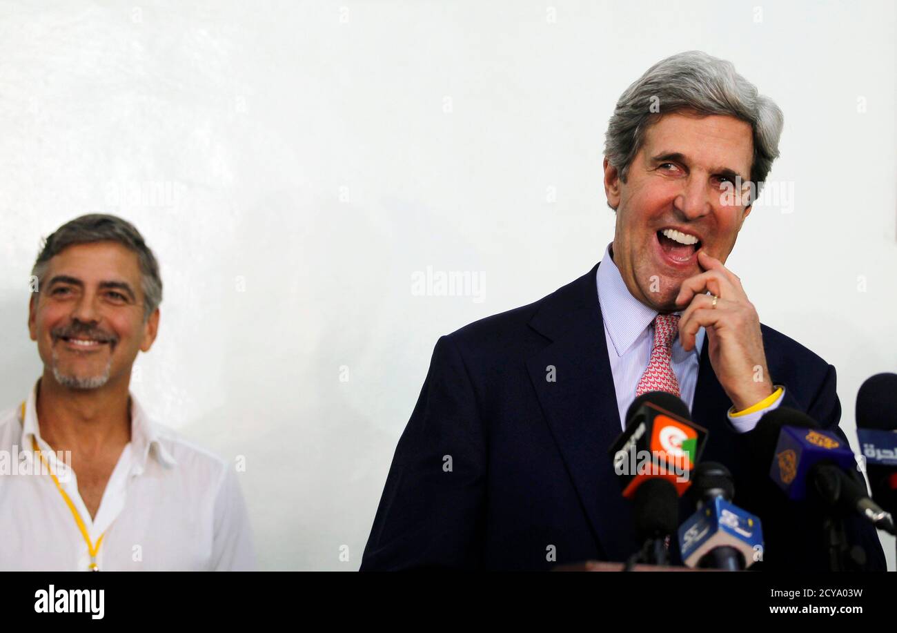 U.S. Senator John Kerry (R), flankiert von Schauspieler George Clooney, befasst sich mit eine Pressekonferenz am Flughafen in Juba, Südsudan 9. Januar 2011, nach seinem Besuch in dem Land Bereitschaft für das Referendum über die Unabhängigkeit zu beurteilen. Millionen von jubelnden Süd Sudan am Sonntag in einem Unabhängigkeitsreferendum der lang ersehnte, die erwartet wird, zu sehen, ihren Krieg verwüsteten Region entstehen als eine neue Nation Abstimmung gestartet. REUTERS/Thomas Mukoya (SUDAN - Tags: Wahlen Politik Unterhaltung) Stockfoto
