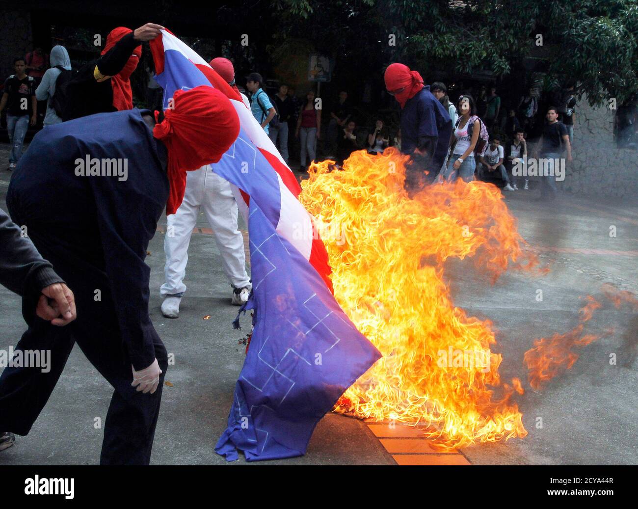 Aktivisten verbrennen die US-Flagge an der Universität von Antioquia, als sie gegen den Americas Summit protestieren, der am 13. April 2012 in Cartagena in Medellin stattfinden wird. Staatsoberhäupter treffen sich auf dem Gipfel vom 14. Bis 15. April. REUTERS/Albeiro Lopera (KOLUMBIEN - Tags: POLITISCHE UNRUHEN) Stockfoto