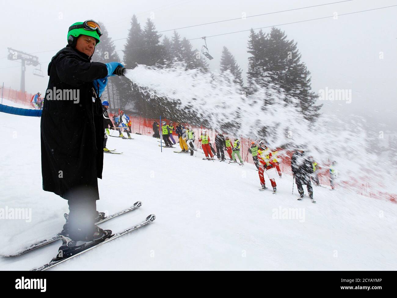 Ehemaliger Schweizer Skifahrer Hans Pieren sprüht Wasser auf dem Platz vor  dem ersten Lauf der Slalom-Rennen der Herren bei der Alpine Ski  Weltcup-Finale in Lenzerheide 19. März 2011. REUTERS/Wolfgang Rattay ( Schweiz -