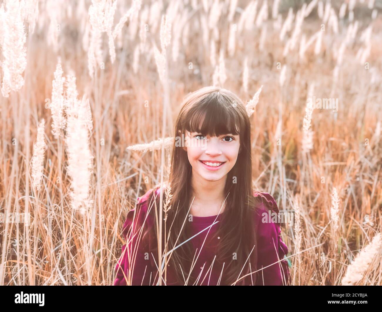 Spaß am Herbst. Herbst Saison Natur Foto von einem niedlichen lächelnden Teenager-Mädchen bei wilden flauschigen Spikes gelben Feld Stockfoto