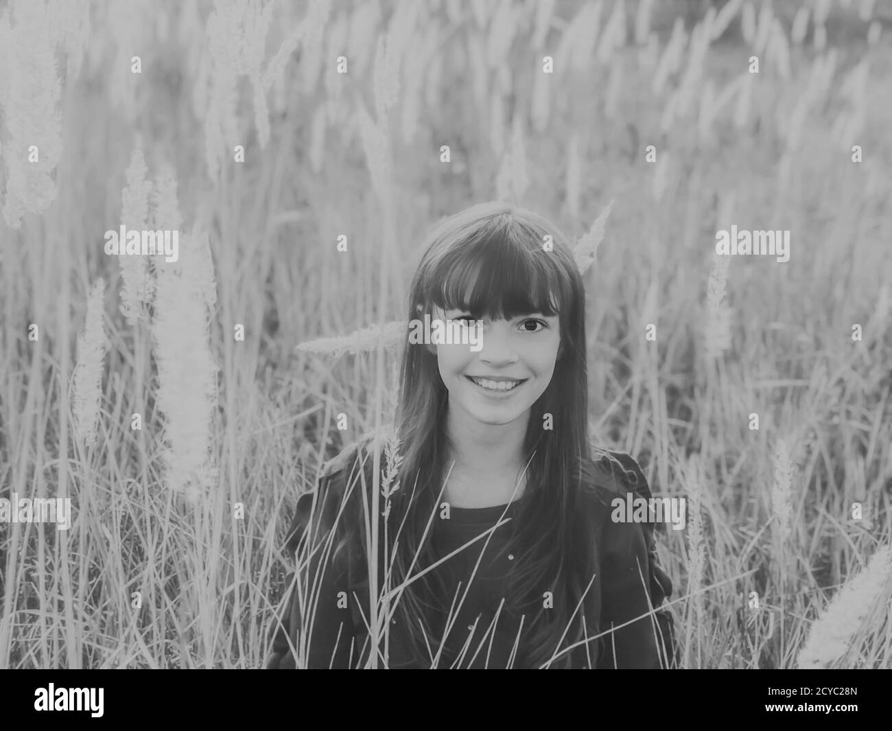 Spaß am Herbst. Herbst Saison Natur Grautöne Foto von einem niedlichen lächelnden Teenager-Mädchen bei wilden flauschigen Spikes Feld Stockfoto