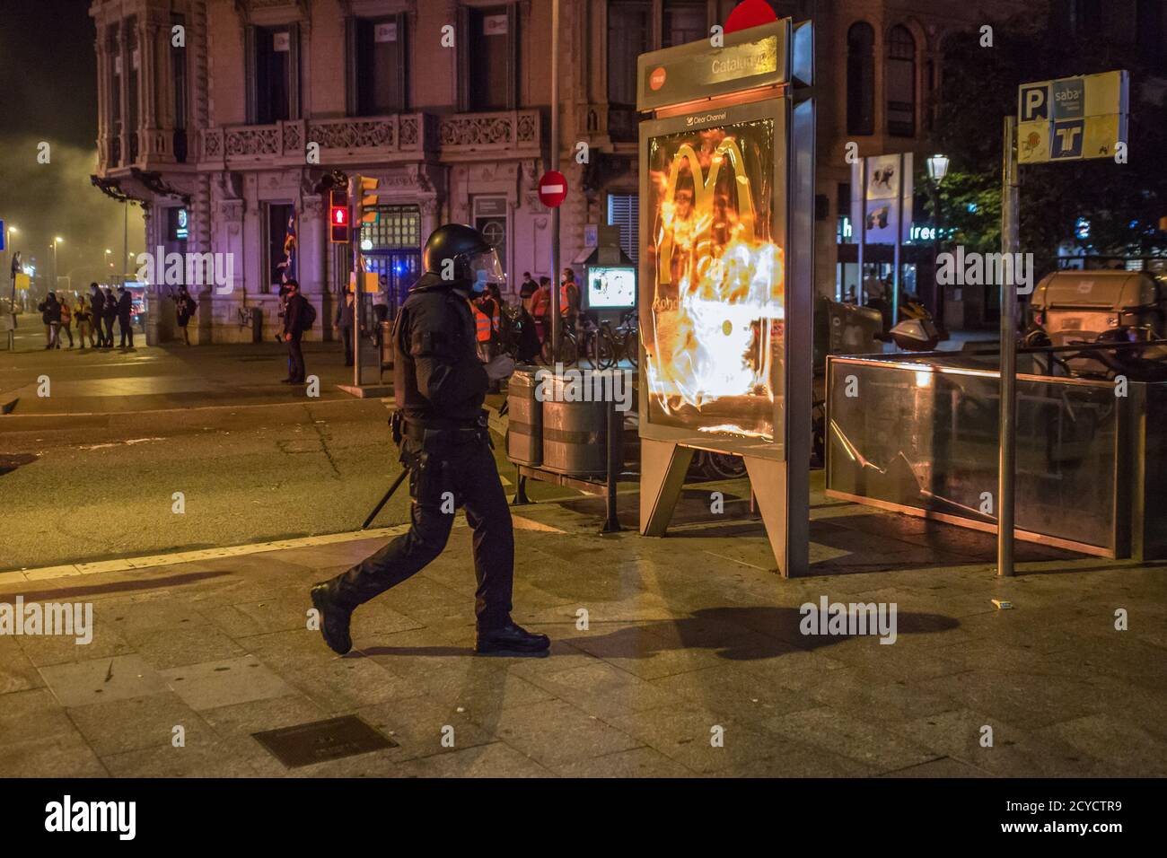 Barcelona, Spanien. Oktober 2020. Polizeibeamter sieht die brennenden Container an. Am 3. Jahrestag des 1. Oktober 2017, dem Tag, an dem ein Unabhängigkeitsreferendum für Katalonien abgehalten wurde, das von der spanischen Regierung verboten wurde und durch die gewaltsame Intervention der Polizei gekennzeichnet war. Demonstranten, die sich für die Unabhängigkeit einsetzen, marschierten auf den Straßen Barcelonas. Kredit: SOPA Images Limited/Alamy Live Nachrichten Stockfoto