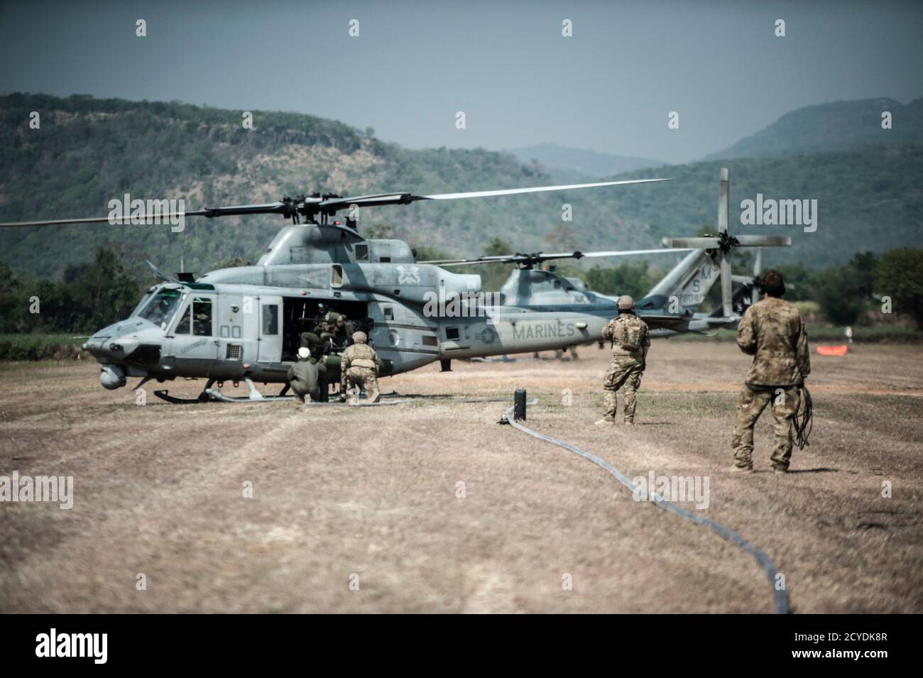 U.S. Air Force 18th Logistics Readiness Squadron Forward Area Tanken Point (FARP) Techniker und 1st Special Operations Squadron Ladmasters führen FARP Operationen mit einem U.S. Marine Corps 1st Marine Aviation Wing UH-1 Huey 14. Februar 2018, in Chandy Range, Thailand. Die FARP-Fähigkeit der 353rd Special Operations Group ermöglicht die Projektion der US-Militärmacht durch die Betankung von Flugzeugen, die an vorausgestellten Standorten im Indo-Asien-Pazifik-Raum eingesetzt werden. (USA Luftwaffe Foto von Capt. Jessica Tait) Stockfoto