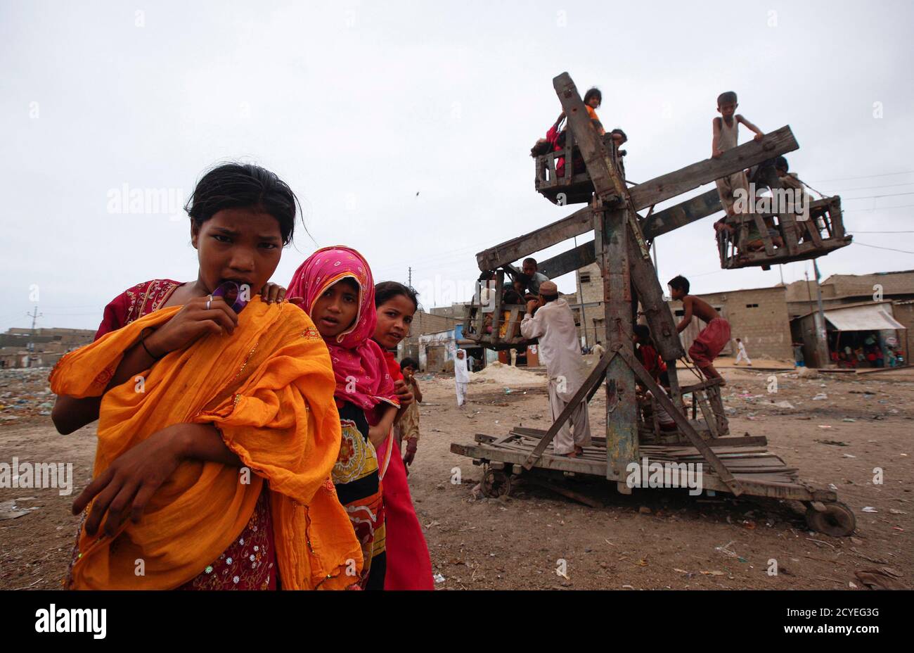 Kinder aus einem Slum werden in Karachi am 19. August 2012 bei einer Schaukelfahrt in der Nähe von anderen dargestellt. REUTERS/AKHTAR SOOMRO (PAKISTAN - TAGS: GESELLSCHAFT ARMUT TPX BILDER DES TAGES) Stockfoto