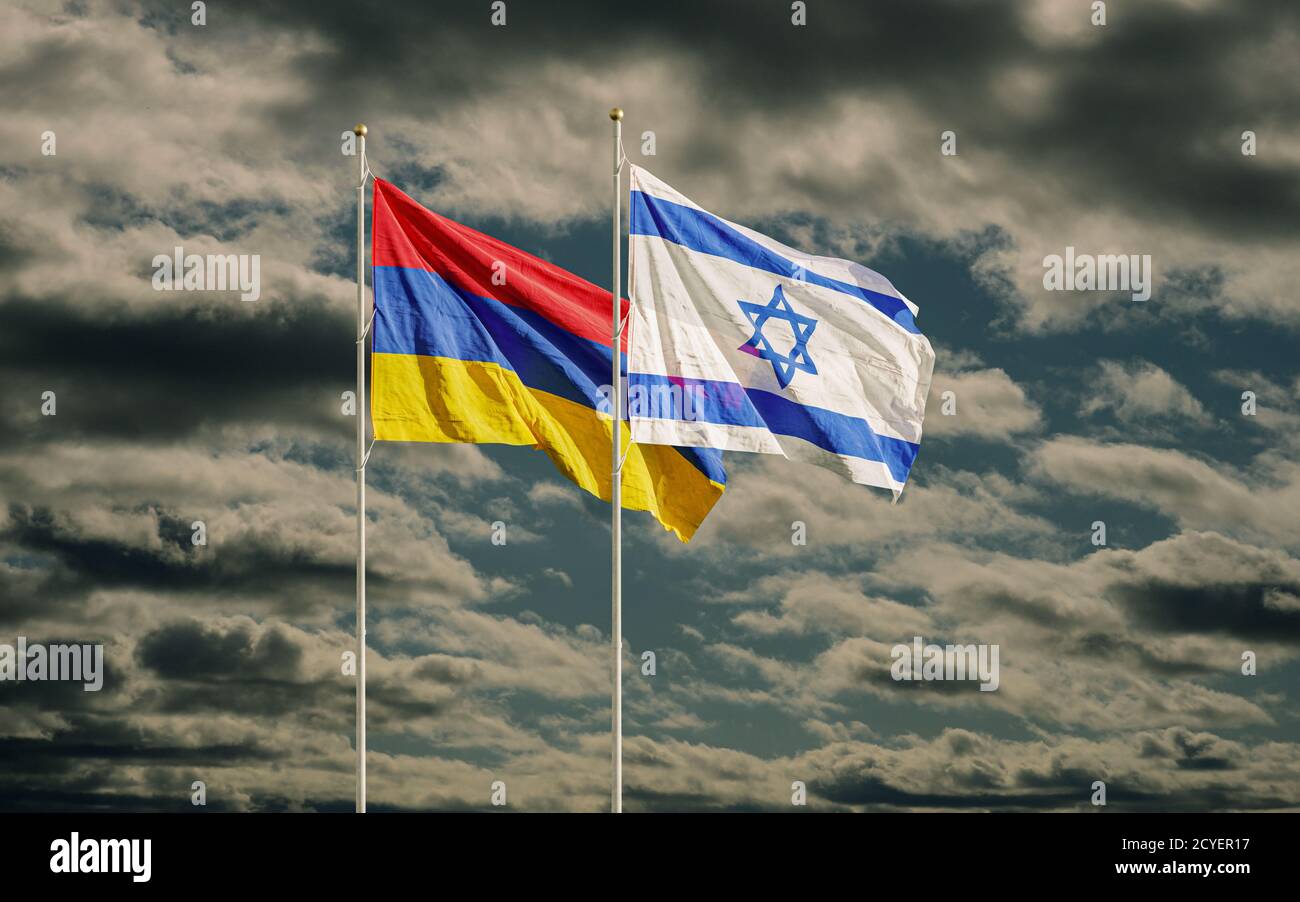 Israelische und armenische Flaggen winken in dunklem Himmel. Symbol der Beziehungen zwischen zwei Ländern. Armenien erinnert an Botschafter in Israel wegen Waffenverkäufen an Azerb Stockfoto