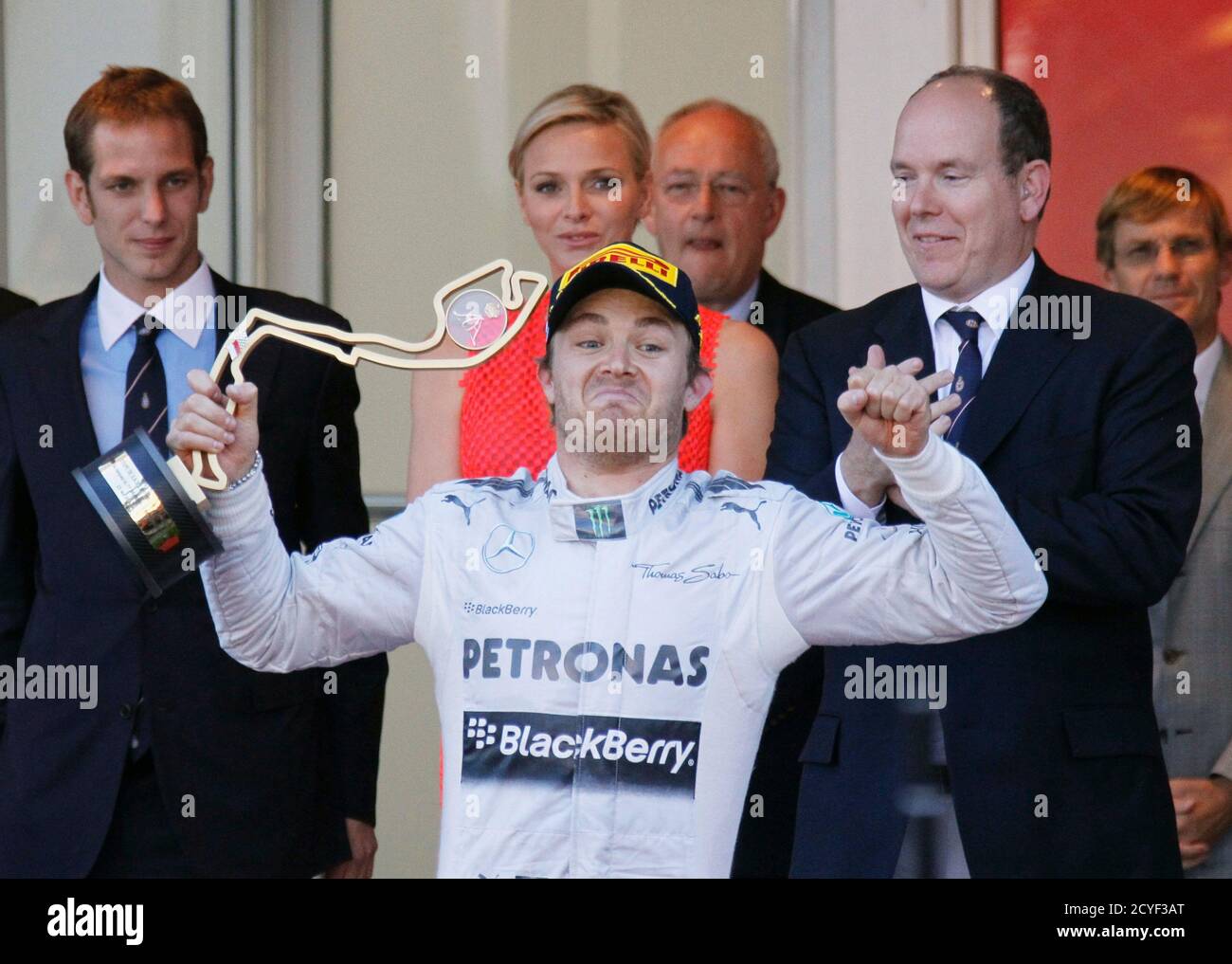 Mercedes Formel-1-Pilot Nico Rosberg aus Deutschland feiert, wie er die Trophäe nach dem Gewinn des Monaco F1 Grand Prix am 26. Mai 2013. Dahinter sehen sich der Fürst Albert II. Von Monaco, Prinzessin Charlene (C) und Pierre Casiraghi (L), der Sohn von Monacos Prinzessin Caroline. . REUTERS/Robert Pratta (MONACO - Tags: SPORT MOTORSPORT F1) Stockfoto