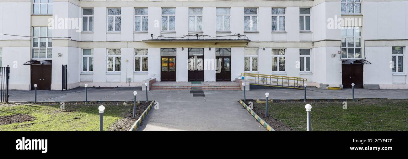 Schulgebäude mit leerem Innenhof. Klassisches lichtverputztes Schulhaus in Moskau, ein typisches Gebäude für Bildungseinrichtungen in den 30-50er Jahren Stockfoto