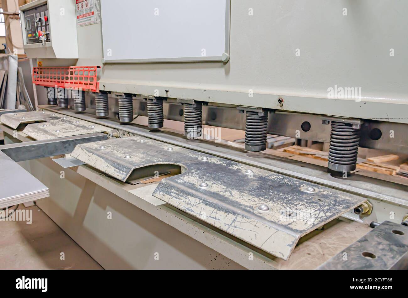 Die scharfen Zähne der Bandsäge auf der modernen Rotmetall-Bearbeitungsmaschine sorgen dank der Einstelllinie für eine hohe Schnittgenauigkeit. Nahaufnahme. Stockfoto