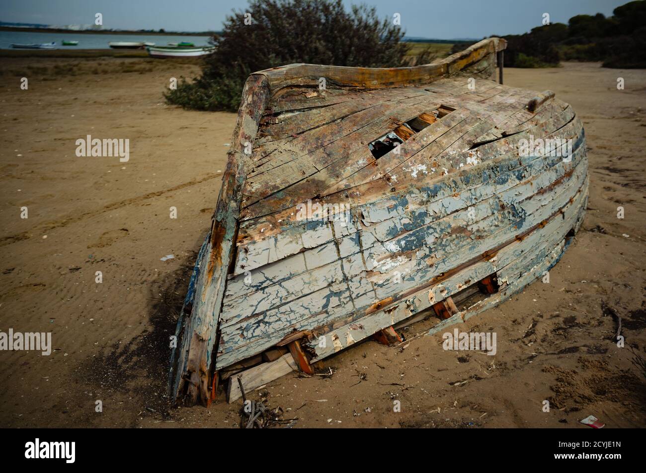 Alte verlassene beschädigte Fischerboot umgedreht am Strand Stockfoto