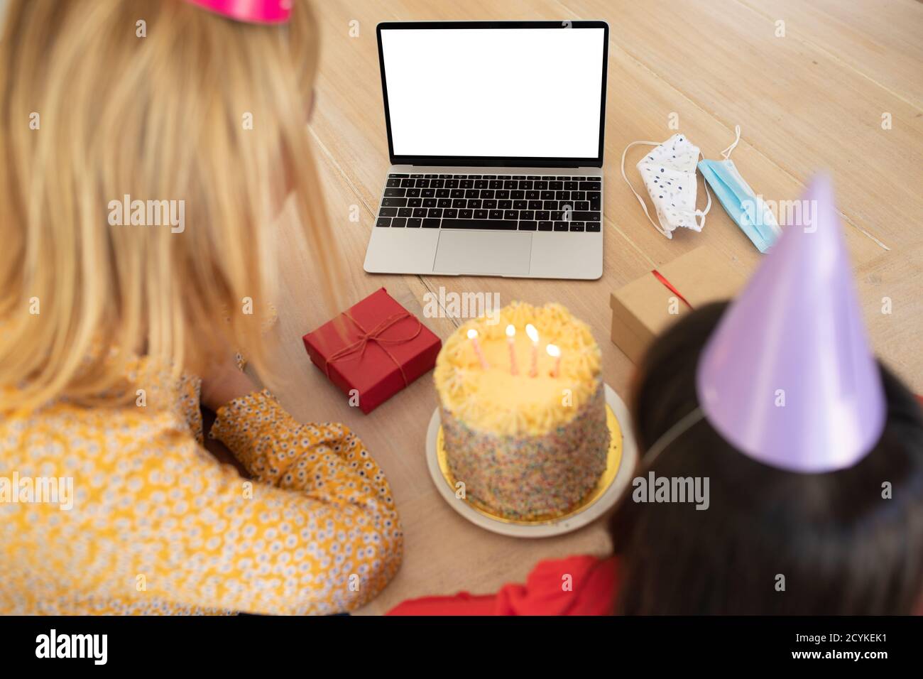 Mutter und Tochter in Party Hut mit Laptop zu Hause Stockfoto