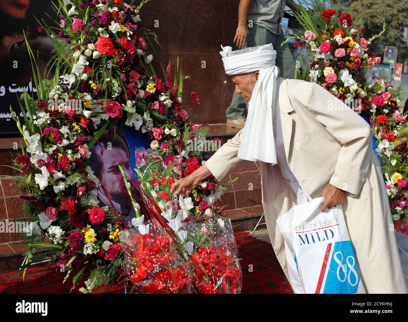 Ein afghanischer Mann legt Blumen auf einem Porträt von getöteten afghanischen Nationalhelden Ahmad Shah Masood während einer Zeremonie anlässlich des 10. Jahrestags seines Todes in Kabul 9. September 2011. Masood oder Löwe von Panjshir gekämpft die Taliban an der Spitze der Nordallianz Afghanistans ethnischen Minderheiten, bis zu seiner Ermordung zwei Tage vor dem 11. September 2001 Angriffe darstellt.  REUTERS/Omar Sobhani (AFGHANISTAN - Tags: Jubiläums-Politik) Stockfoto