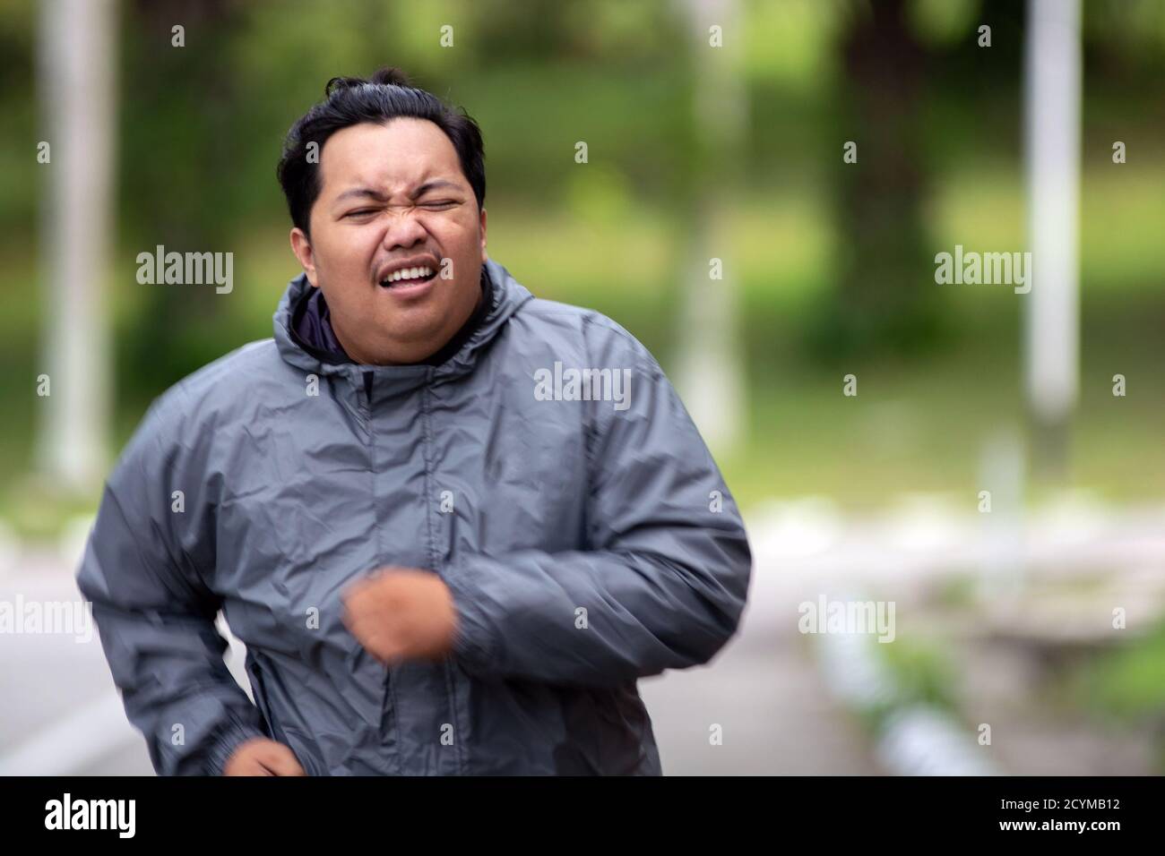 Portrait of Fat man Gefühl müde zu joggen im Park. Es muss Gewicht zu verlieren und den perfekten Körper zu bekommen. Stockfoto