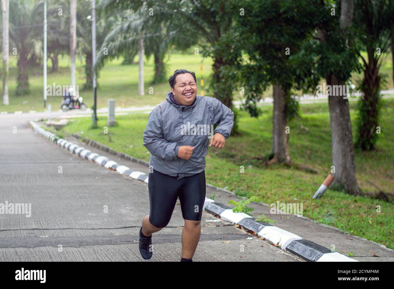 Portrait of Fat man Gefühl müde zu joggen im Park. Es muss Gewicht zu verlieren und den perfekten Körper zu bekommen. Stockfoto