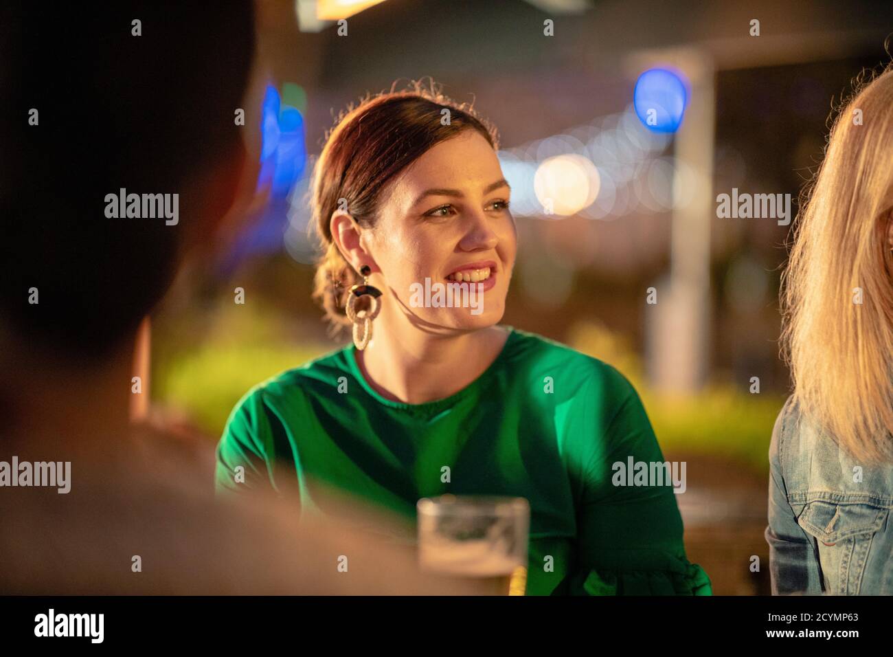 Ein kaukasisches Mädchen, das mit ihren Freunden in einer Bar/Restaurant alkoholische Getränke trinkt, feiert und Spaß zusammen hat. Stockfoto