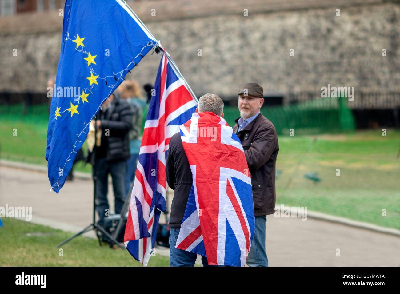 Brexit-Anhänger drapiert in einer Gewerkschaft Jack Flagge diskutieren die Sackgasse mit einem EU-Anhänger auf College Green, von den Houses of Parliament, London Stockfoto