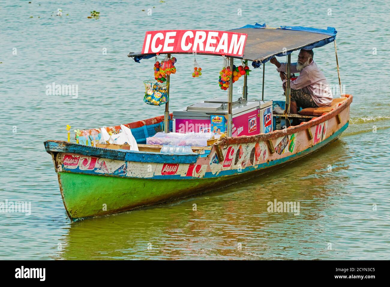 Mann, der Eis vom Boot auf dem See Vembanad auf den Backwaters verkauft, die für Hausbootkreuzfahrten populär sind; Alappuzha (Alleppey), Kerala, Indien Stockfoto