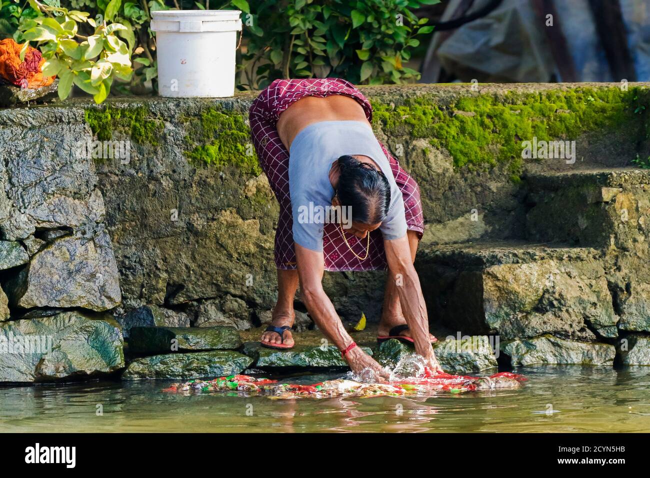 Frau waschen Kleidung in traditioneller Weise auf den Backwaters in diesem Wasserstraßen-Bezirk; Alappuzha (Alleppey), Kerala, Indien Stockfoto