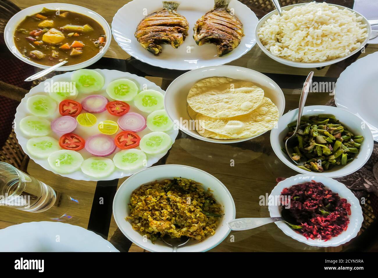 Typische indische Mahlzeit auf dem Hausboot: Reis, Bohnen, Kohl, Curry, Papad, gebratener Fisch; Alappuzha (Alleppey), Kerala, Indien Stockfoto