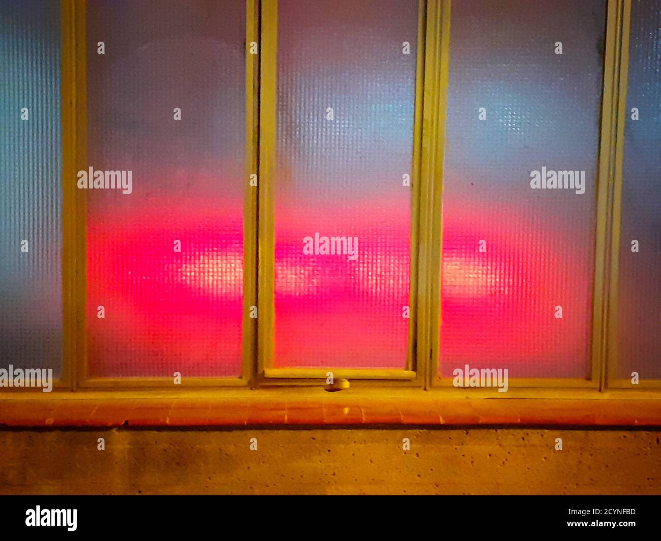 Rote Lichter hinter einem durchscheinenden Glas. Stockfoto