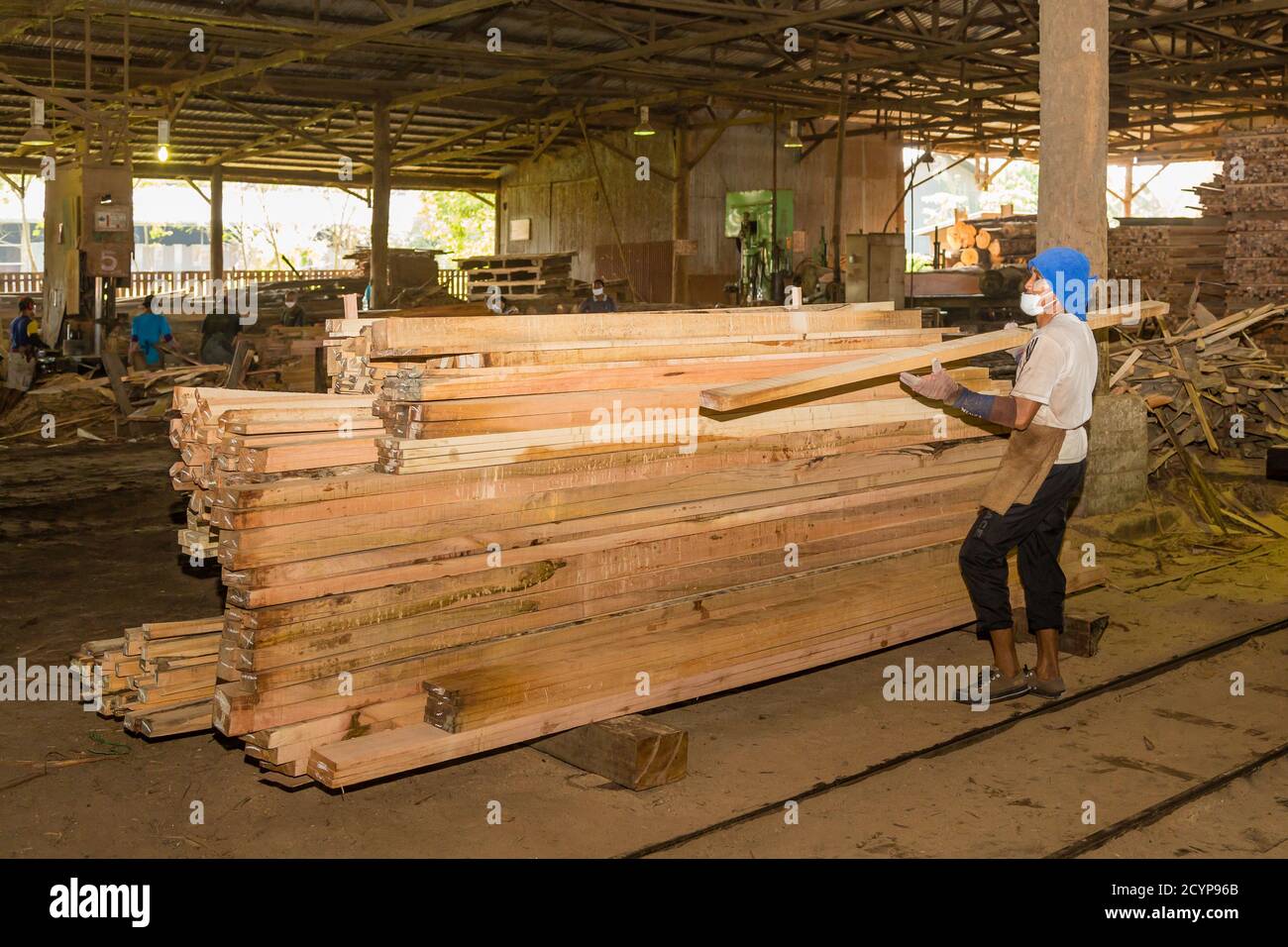 Ein Arbeiter sortiert Schnittholz in einem Sägewerk im Industriegebiet Seguntor in Sandakan, Sabah Stockfoto