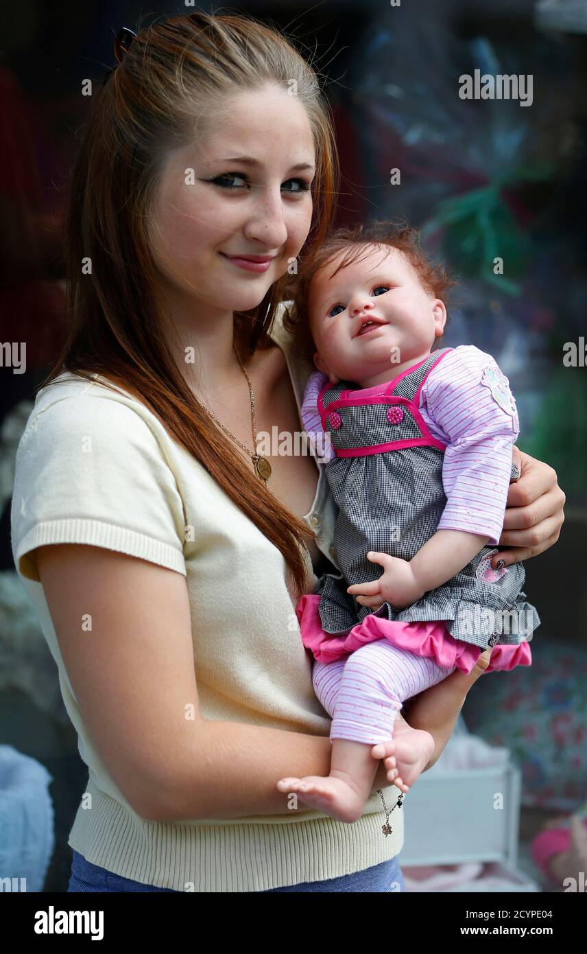 Stacy, 19, aus Belgien, Posen mit Stefy, ihre lebensechten "Reborn Baby"  Puppe außerhalb belgische Künstler Beatrice Van Landeghem Werkstatt,  genannt "La Nurserie des Tis Lous De Bea" in La Louviere, Südbelgien 8.