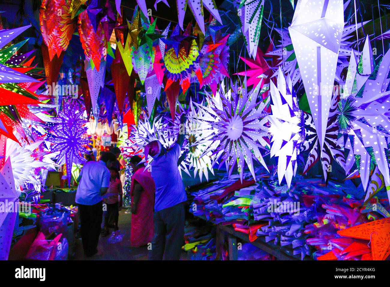 Bunte Weihnachtssterne beleuchtet in einem Weihnachtsmarkt in Kerala Goa Indien. Indisches Weihnachtskonzept Blitz Papier Laterne oder Stern hängen Stockfoto