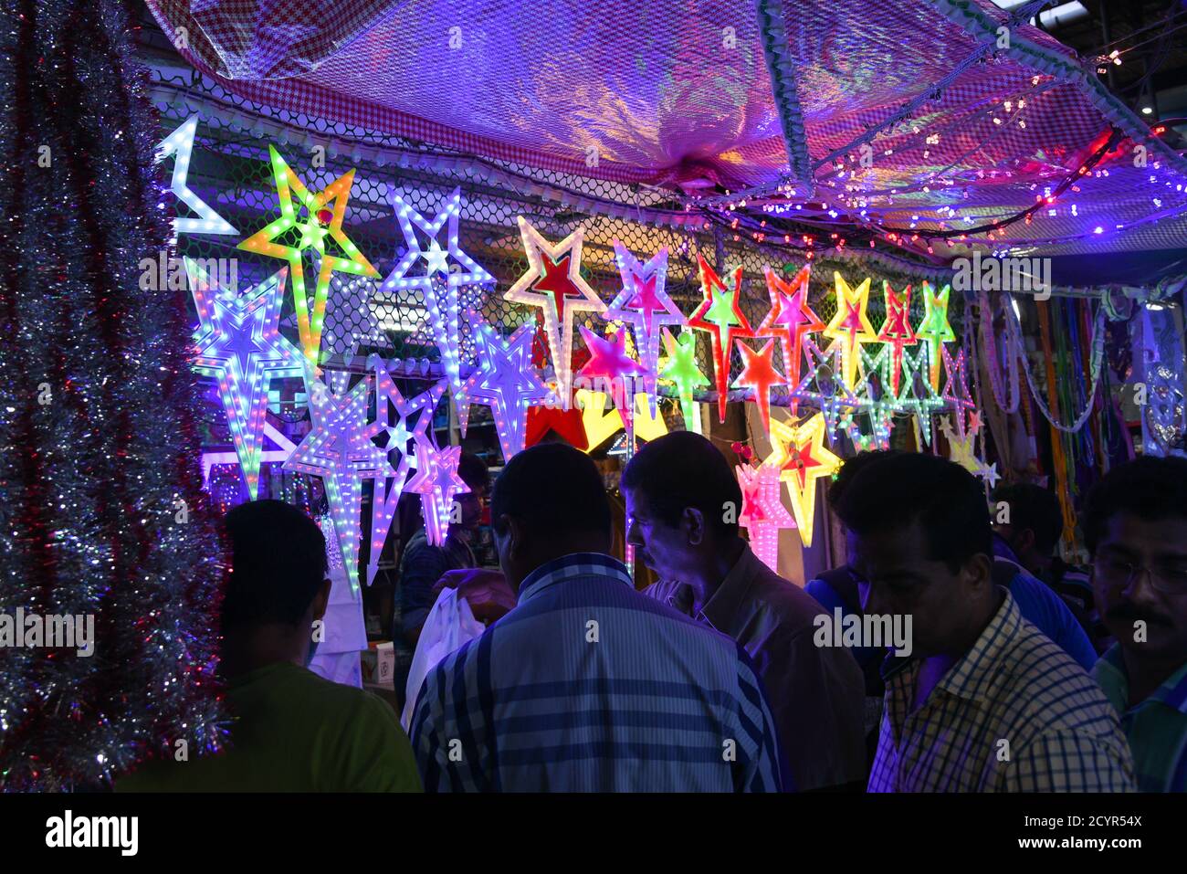 Bunte Weihnachtssterne beleuchtet in einem Weihnachtsmarkt in Kerala Goa Indien. Indisches Weihnachtskonzept Blitz Papier Laterne oder Stern hängen Stockfoto