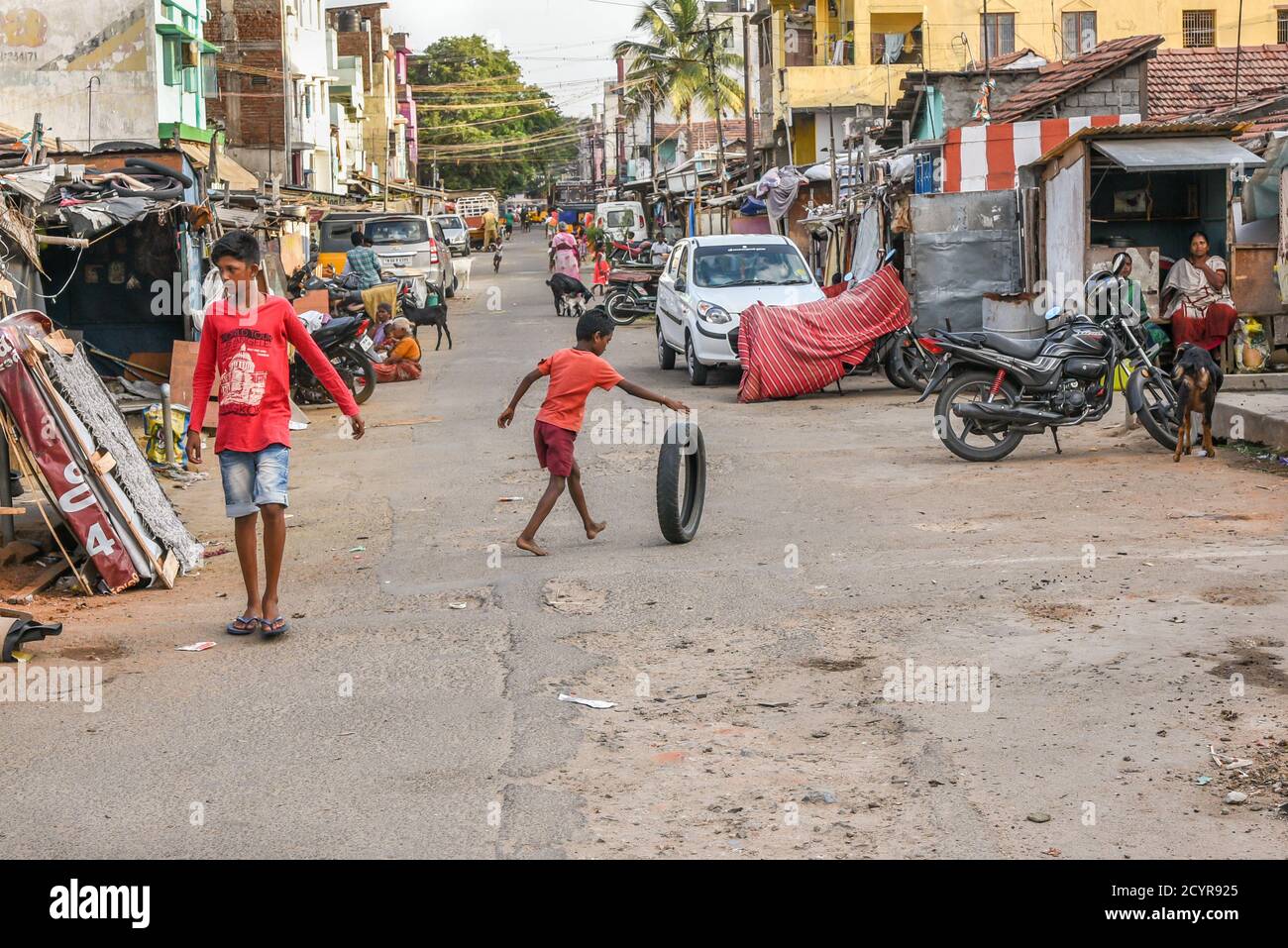 TAMILNADU, INDIEN - 09. FEBRUAR 2016: Arme indische Kinder oder Jungen, die mit Autoreifen in einem ländlichen indischen Slum in Coimbatore spielen. Stockfoto