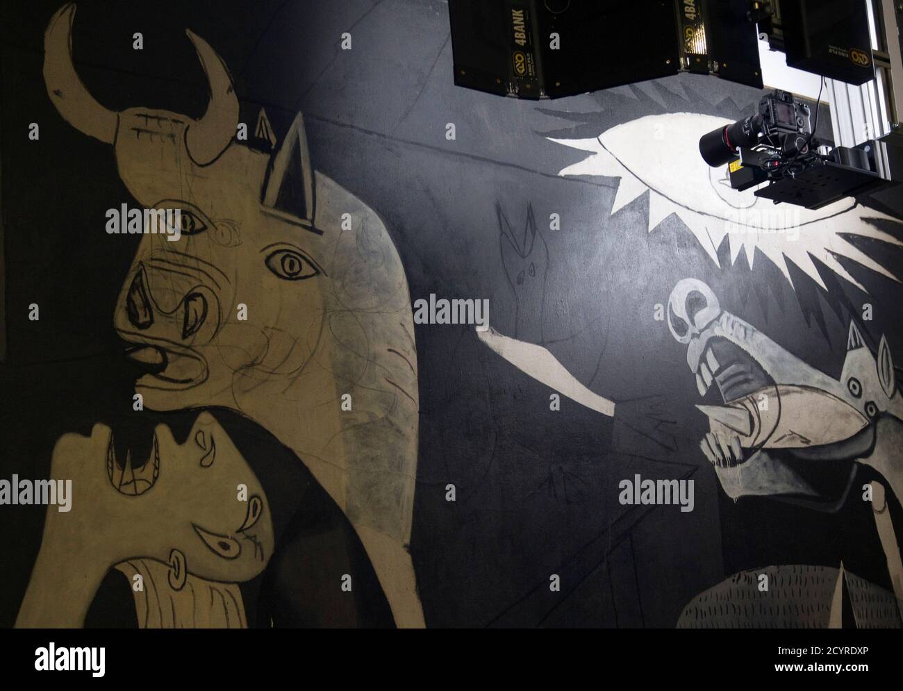 Eine Kamera auf einer mobilen roboterähnlichen Struktur bewegt sich über Pablo Picassos 'Guernica' Gemälde im Reina Sofia Museum in Madrid 28. Februar 2012. Experten sorgen sich schon lange um die Gesundheit von Picassos 'Guernica', einem der ikonischsten Gemälde der Welt, das aber nach einem hektischen Leben als äußerst empfindlich diagnostiziert wird. Eine mobile, roboterartige Struktur, die fortschrittliche Infrarot- und Ultraviolettfotografietechnologie verwendet, nimmt Tausende von mikroskopischen Aufnahmen des Gemäldes auf, um Analysten zu ermöglichen, das Werk wie nie zuvor zu durchdringen und seinen wahren Zustand zu sehen. Der Mechanismus hat sein Stockfoto