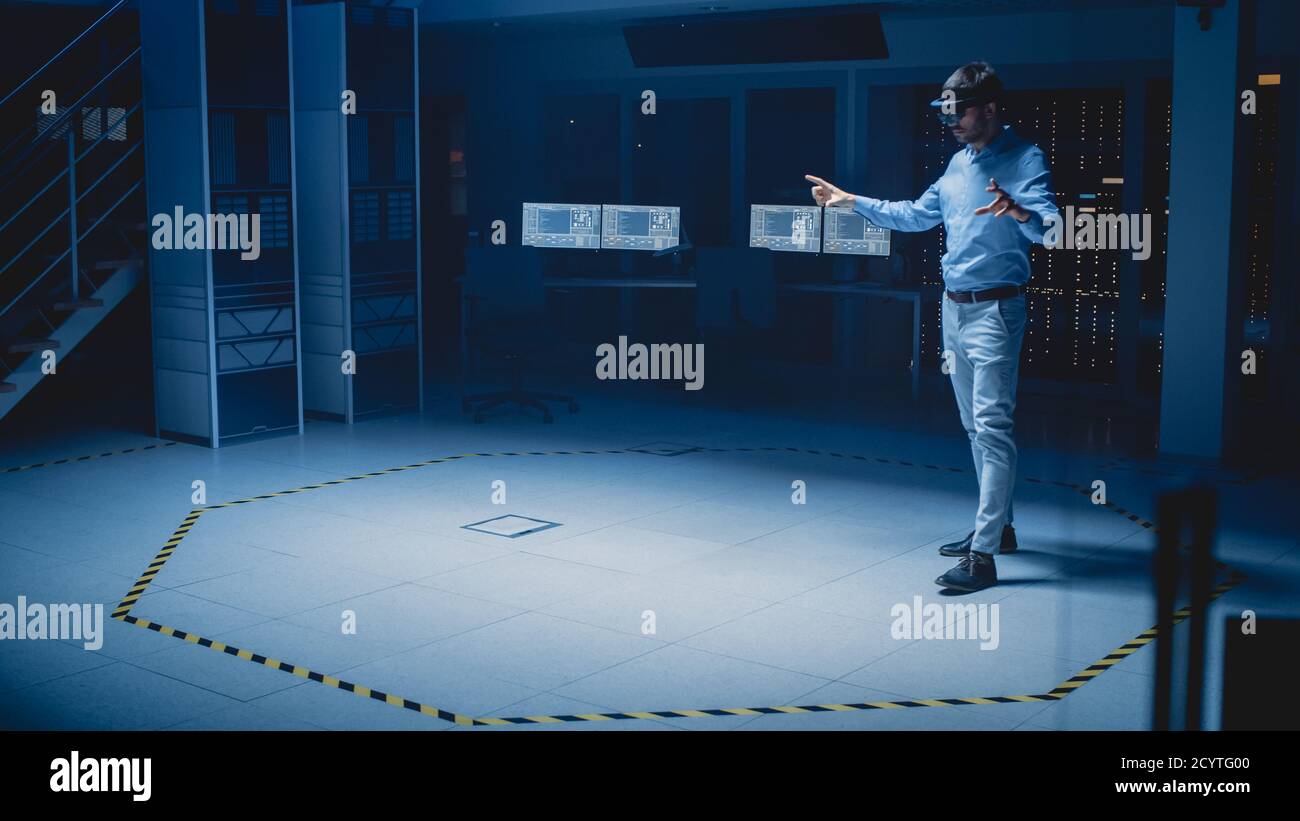 In 3D Content Creating Laboratory Engineer Wearing Professional Virtual Reality Headset funktioniert und Gesten in Augmented Reality. Industrielle Software Stockfoto