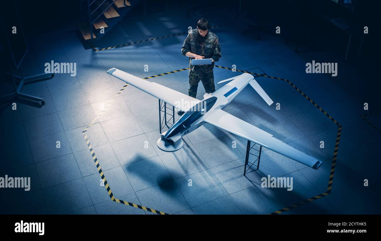 Army Aerospace Engineer Arbeit An Unbemannten Luftfahrzeug Drohne. Uniformierte Aviation Expert Mit Laptop. Industrieanlage mit Überwachung, Kriegsführung Stockfoto
