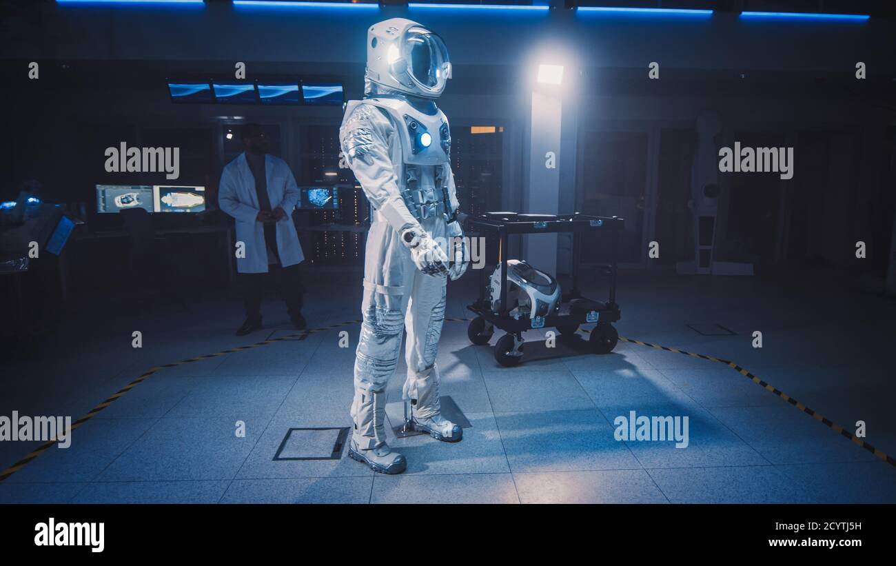 Low Angle Shot eines Astronaut Space Suit angepasst für Raum und Reise Exploration Stehen in einem Luft-und Raumfahrt-Entwicklungslabor. Wissenschaftler und Stockfoto