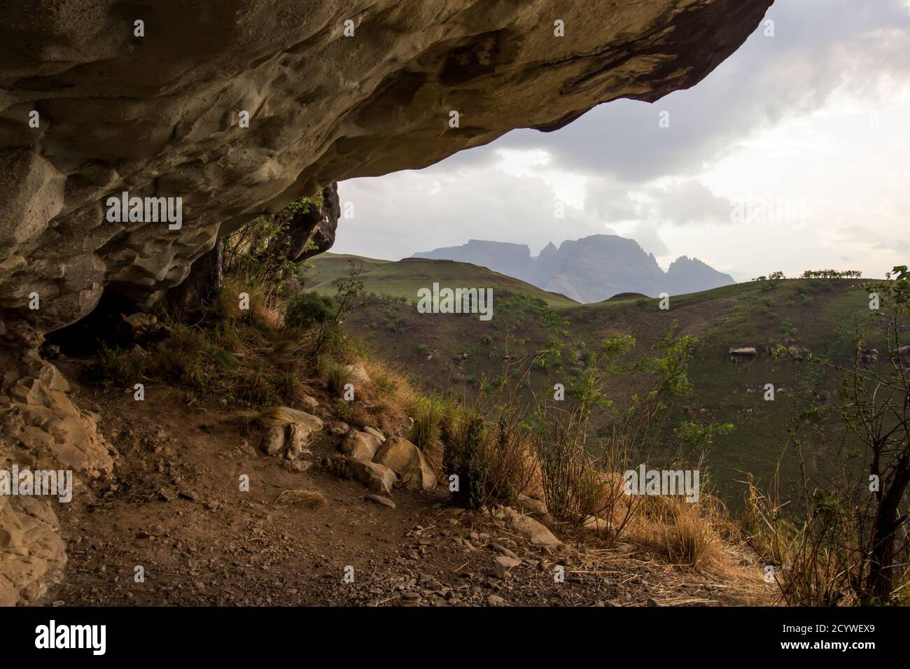 Wonder Cave, eine flache Übernachtungshöhle in den Drakensberg Mountains, Südafrika, mit dem Monk's Cowl Peak im Hintergrund am späten Nachmittag Stockfoto