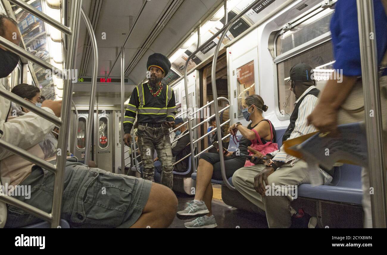Mann geht maskless auf einem NYC Uptown #4 Zug auf der Lexington Linie. Aufgrund der Covid-19-Pandemie sind in den Zügen Masken obligatorisch. Immer noch viele Menschen aufgrund nicht immer mit den Regeln. Stockfoto