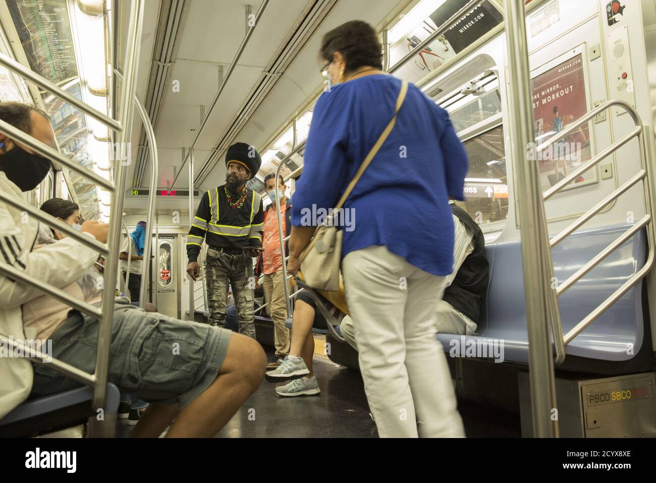 Mann geht maskless auf einem NYC Uptown #4 Zug auf der Lexington Linie. Aufgrund der Covid-19-Pandemie sind in den Zügen Masken obligatorisch. Immer noch viele Menschen aufgrund nicht immer mit den Regeln. Stockfoto