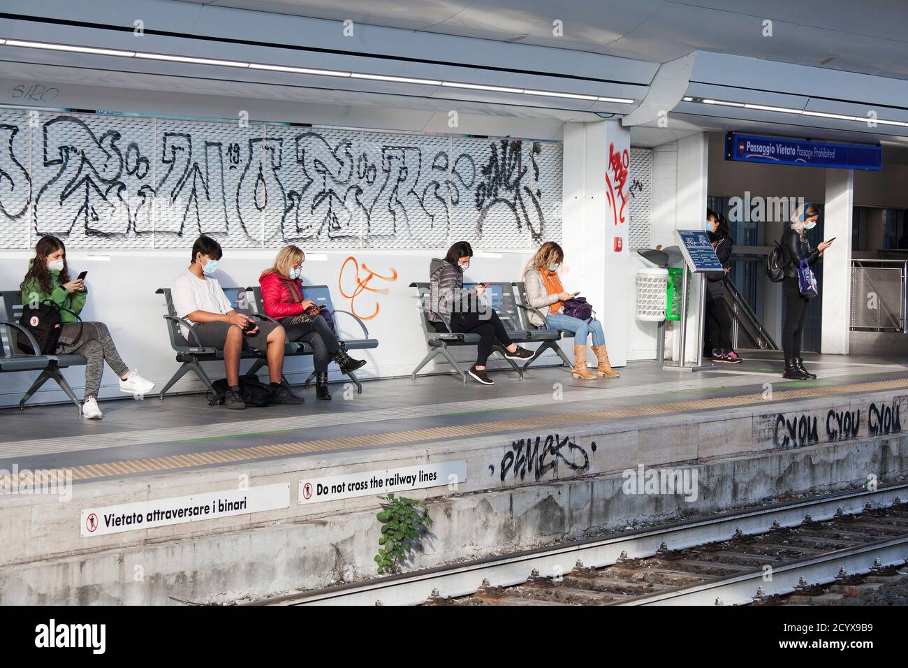 ROM, ITALIEN - OKTOBER 01 2020: Pendler, die Schutzmasken tragen, warten in Rom, Italien, auf einen Zug. Stockfoto