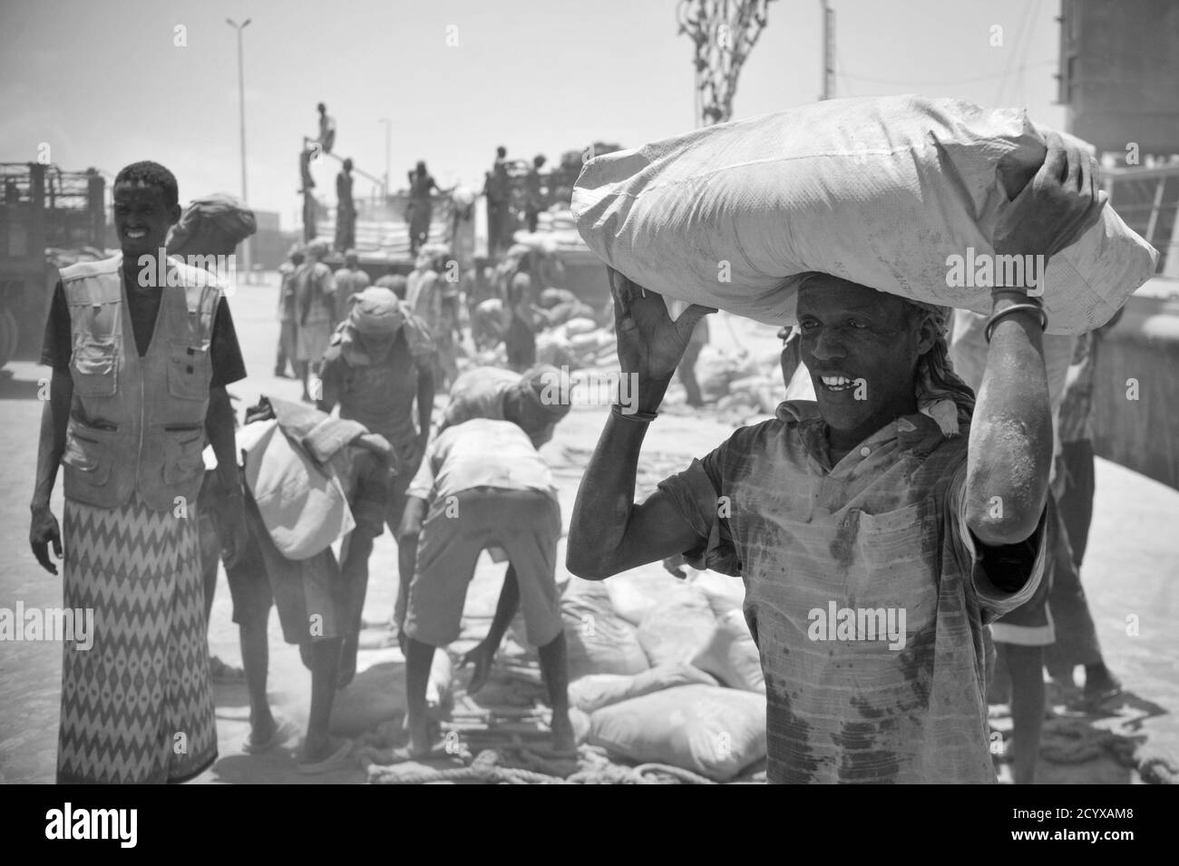 Am 15. April brachte ein somalischer Mann Zement von einem Schiff zu einem wartenden LKW im Haupthafen von Mogadischu. Trotz der anhaltenden Bedrohung durch al-Shabaab wächst die Wirtschaft der Hauptstadt weiter, und das tägliche Leben normalisiert sich wieder. Stockfoto